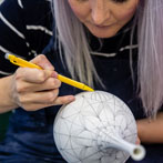 Rhian Malin decorating a mandala bottle in her workshop 2019